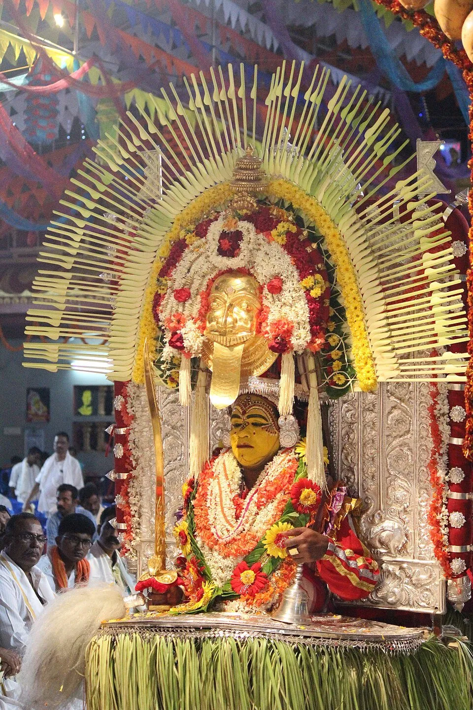 Jarandaya at a kola, seated under a tall halo of palm ribs