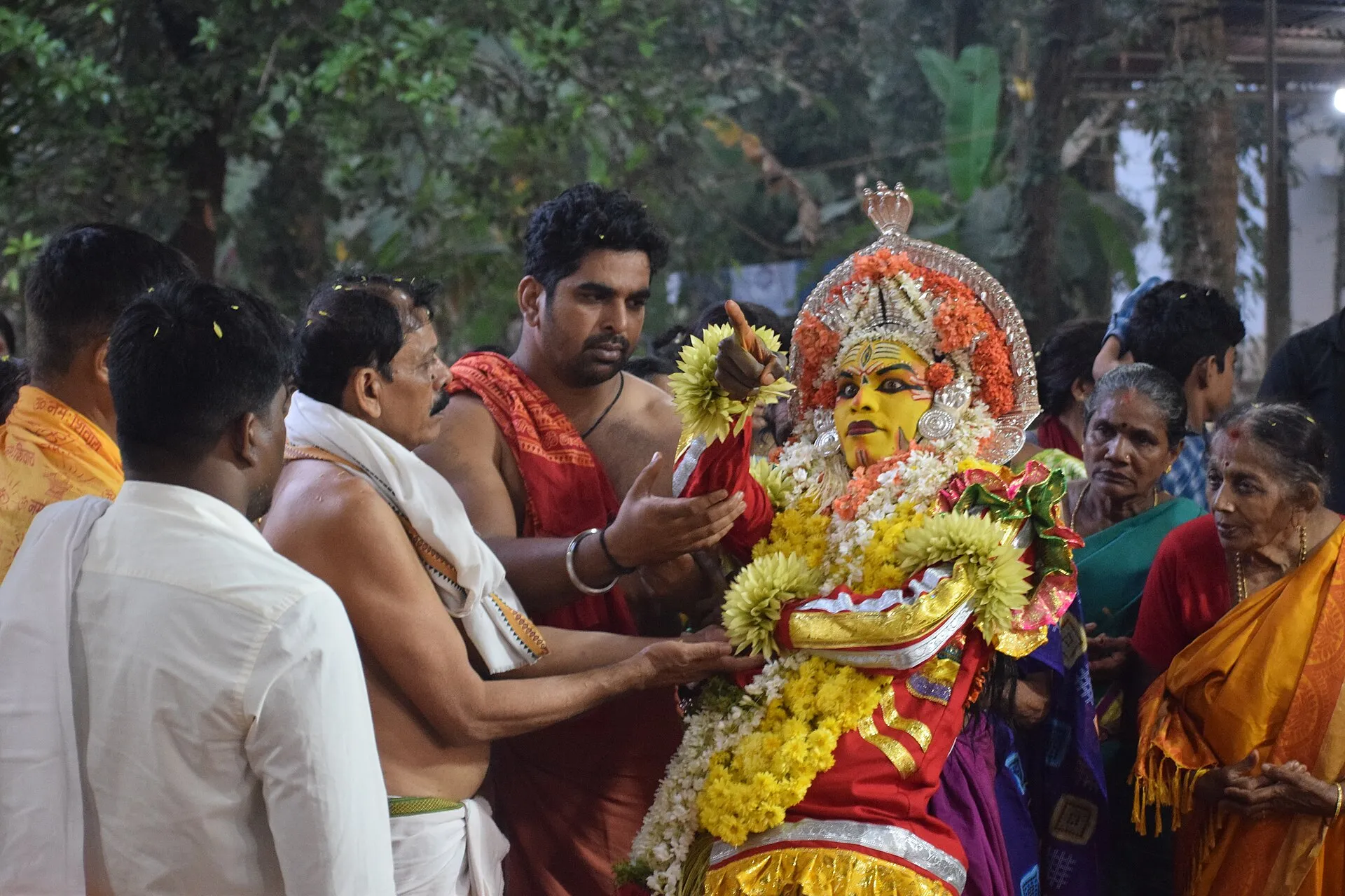 Villagers gather close around Panjurli during a kola