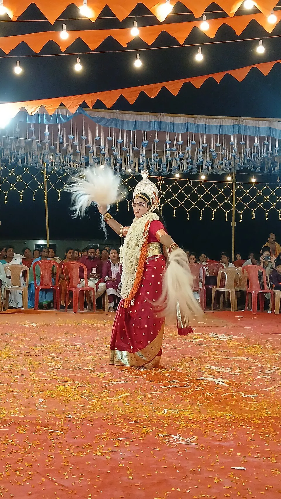 Tannimaniga dancing at a kola in a red sari with a white fan