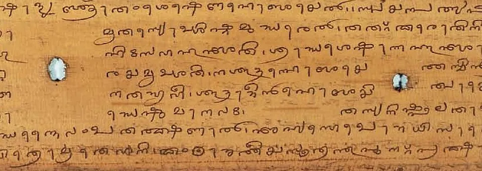 A palm-leaf folio with lines of Tigalari script and two string holes