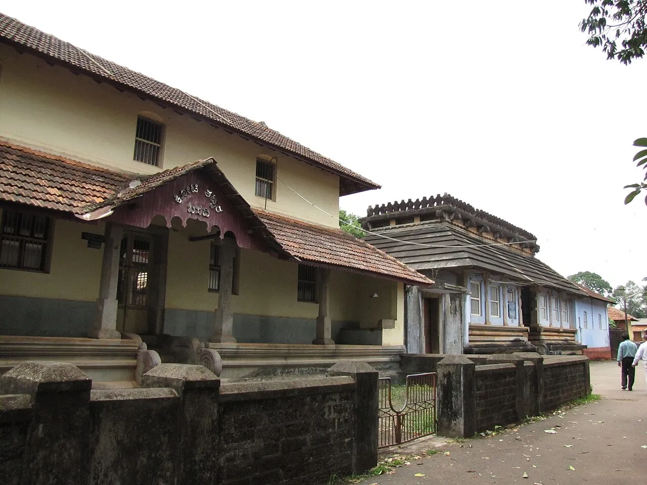 The Koti Basadi and Guru Basadi, low buildings with tiled roofs and carved wooden gables along a quiet street