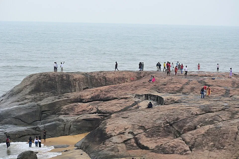 A rocky shore at Someshwara Beach, Ullal, with waves breaking over dark rocks