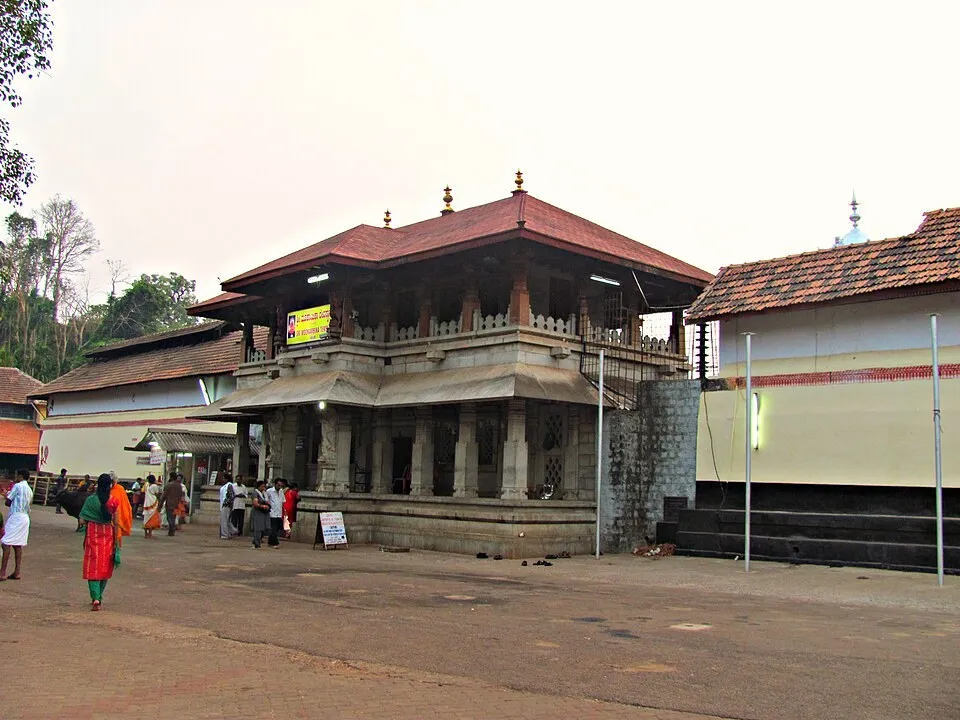 The front of the Mookambika temple at Kollur: a hall with red tiled roofs and a wide forecourt, with a few visitors