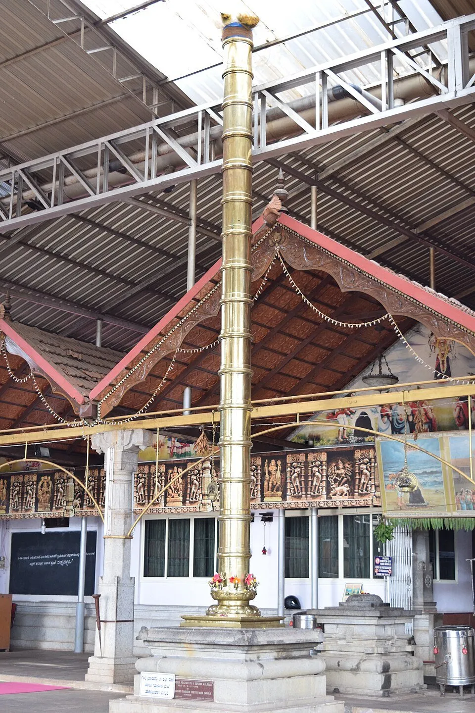 The brass flagstaff and carved wooden gable of the Mangaladevi temple, Mangaluru