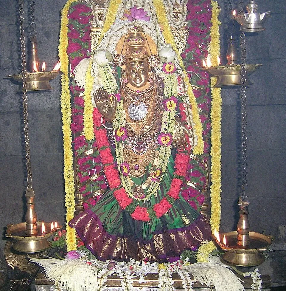 The image of the goddess at the Mundkur temple on a festival day, garlanded with flowers and ornaments between rows of brass lamps